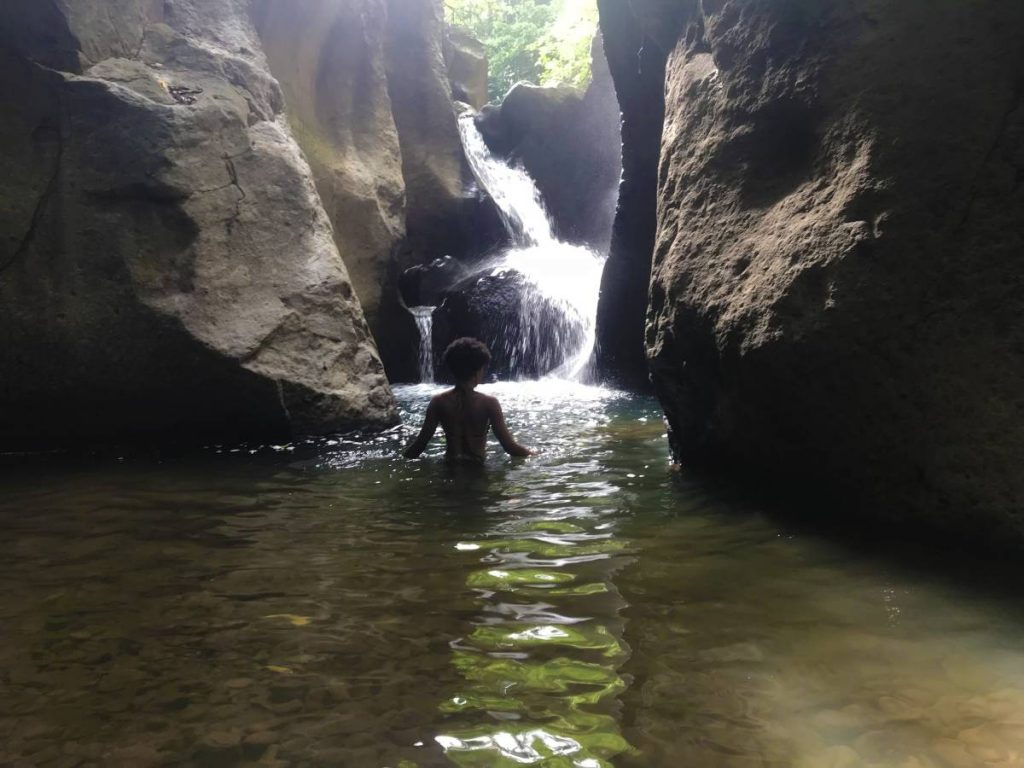 Hiker bathing in waterfall pool